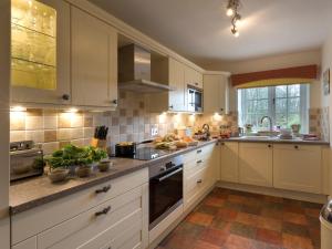 a kitchen with white cabinets and a stove top oven at 2 Bed in Starnthwaite LCC35 in Crosthwaite