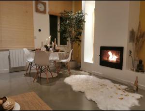 uma sala de estar com uma mesa e uma lareira em Loft Spa La Maison du Bambou em Sequedin