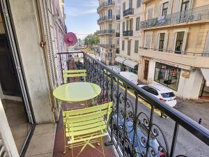 een tafel en stoelen op een balkon met een straat bij Studio with view on Marché Forville for 2 128 in Cannes