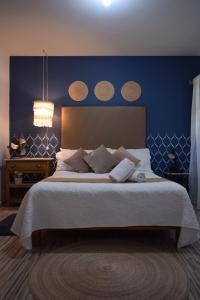 a bedroom with a large bed with a blue wall at Casa Miranda Morelos in Guadalajara