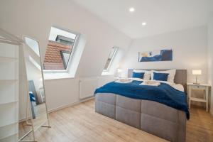 a bedroom with a bed with blue sheets and a window at City Center Maisonette Apartment für 8 Personen in Weimar