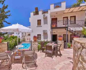 a patio with a table and chairs and a building at Zahna Apartment in Kaş
