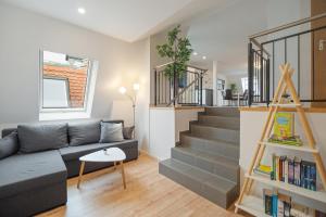 a living room with a couch and a staircase at City Center Maisonette Apartment für 8 Personen in Weimar