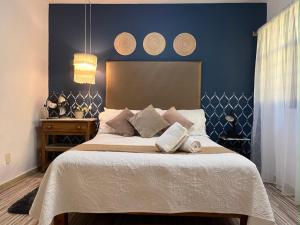 1 dormitorio con 1 cama grande y pared azul en Casa Miranda Morelos, en Guadalajara