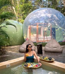 une femme assise à l'eau dans une piscine dans l'établissement Oom Bubble Boutique Riviera Cancun, à Puerto Morelos