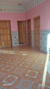 an empty room with pink walls and a tile floor at Maroc Galacx in Ouarzazate