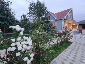 uma casa com flores em frente em ВИЛЛА / VILLA em Gabala