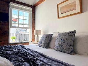 a bedroom with a white bed with a window at Boatsman's Cottage- sleeps 4- Garage- Mousehole in Mousehole
