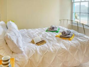 a white bed with towels and books on it at 1 Bed in Tenby 83320 in Tenby