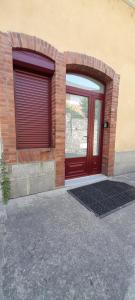 un edificio con una puerta roja y una pared de ladrillo en Lamatacam 9.1 Armoise Duplex 2 chambres en Argelès-Gazost