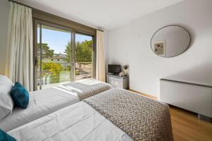 a bedroom with a bed and a large window at Duplex Can Volanti in Port de Pollensa