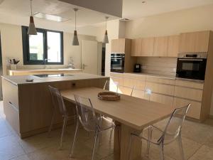 een keuken met een houten tafel en stoelen en een aanrecht bij Villa proche océan et golf in Anglet