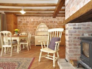 a living room with a fireplace and a table and chairs at 2 Bed in Newthorpe 47031 