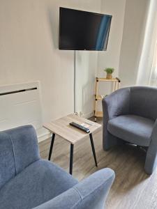 ein Wohnzimmer mit 2 Stühlen und einem TV in der Unterkunft Joli studio du Vallespir in Amélie-les-Bains-Palalda