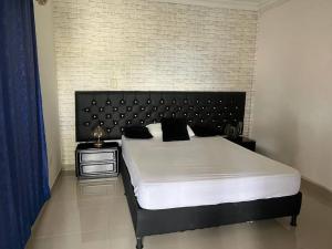 um quarto com uma cama grande e uma cabeceira preta em Casa de lujo muy amplía con ubicación privilegiada em Medellín