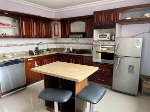 una cocina con armarios de madera y electrodomésticos de acero inoxidable en Casa de lujo muy amplía con ubicación privilegiada, en Medellín