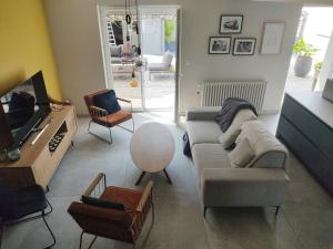 uma sala de estar com um sofá e uma televisão em Villa pour 8 personnes avec SPA à 1 km de la plage em La Baule