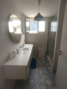 uma casa de banho branca com um lavatório e um espelho em Villa pour 8 personnes avec SPA à 1 km de la plage em La Baule