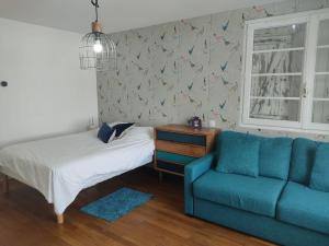 um quarto com uma cama e um sofá azul em Villa pour 8 personnes avec SPA à 1 km de la plage em La Baule