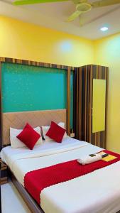 a bedroom with a large bed with red pillows at Hotel Avenue Regency in Mumbai