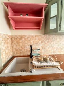 a kitchen counter with a sink with cups on it at Cozy apartment in Galati in Galaţi