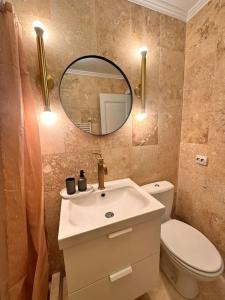 a bathroom with a sink and a toilet and a mirror at Cozy apartment in Galati in Galaţi