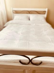 a bed with a white mattress with a cord on it at Cozy apartment in Galati in Galaţi