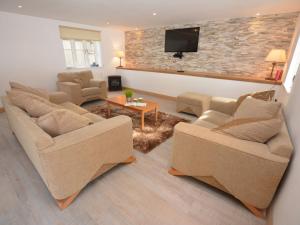 a living room with two couches and a tv at 2 Bed in Fairbourne 43105 in Arthog
