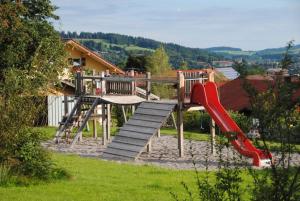 a wooden playground with a slide and a slideintend at Appartement Bergfrieden in Oberstaufen