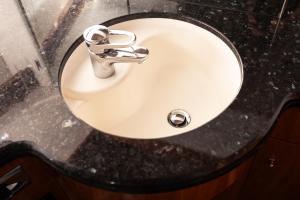 a white bathroom sink with aaucet on a counter at Luxury Yacht "Amato" in Sanremo