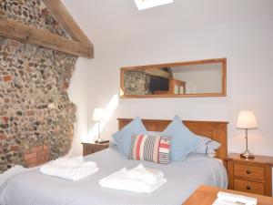 a bedroom with a bed with a stone wall at 2 Bed in Winterton on Sea 29236 in Winterton-on-Sea