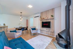 a living room with a blue couch and a fireplace at 1 quadra da Catedral - @stayhousetemporada in Canela