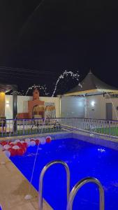 a swimming pool at night with a fountain at شاليه الرتيل in Ash Shuwaybiţ