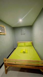 uma cama num quarto com uma parede verde em Mantilla Hostel em Coron