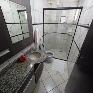 ein Bad mit einer Dusche, einem WC und einem Waschbecken in der Unterkunft Apartamento 102 mobiliado 2 quartos Jaraguá do Sul-SC in Jaraguá do Sul