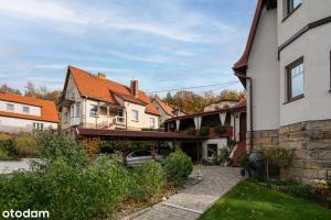 a group of houses with a driveway in a yard at Apartament Rubinowy in Polanica-Zdrój