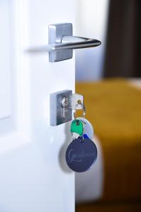 a key chain on a door with a lock at Alba Rosa Rooms in Rome