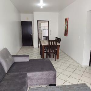 ein Wohnzimmer mit einem Sofa und einem Tisch in der Unterkunft Apartamento 102 mobiliado 2 quartos Jaraguá do Sul-SC in Jaraguá do Sul