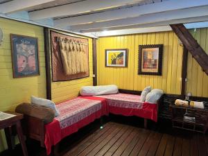 two beds in a room with yellow walls at My Island Home in Fare