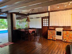 uma sala de estar com uma mesa e uma cozinha com um fogão em My Island Home em Fare