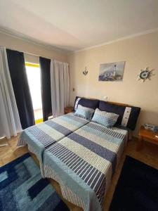 a bedroom with a bed with a blue and white blanket at O Recanto da Rocha in Portimão