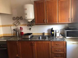 a kitchen with a sink and a microwave at O Recanto da Rocha in Portimão