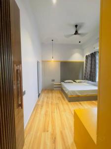 1 dormitorio con 1 cama y suelo de madera en Grazio Outhouse By The Party Citadel en Dahmi