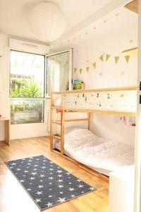 Dormitorio infantil con litera y alfombra en Appartement de 2 chambres avec terrasse et wifi a Bagnolet, en Bagnolet