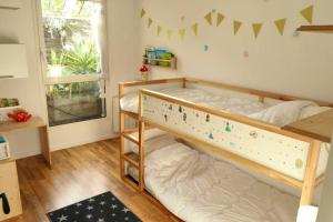 Dormitorio infantil con litera y ventana en Appartement de 2 chambres avec terrasse et wifi a Bagnolet, en Bagnolet