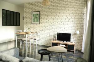 sala de estar con TV, mesas y sillas en Appartement de 2 chambres avec terrasse et wifi a Bagnolet en Bagnolet