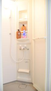 a white bathroom with a shower and a sink at Osaka Shinsaibashi Dotonbori Courtyard Villa in Osaka