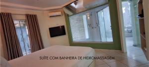 a bedroom with a bed and a large window at Motel Haraam in Araraquara