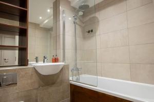 een badkamer met een bad, een wastafel en een douche bij Luxury City Centre Apartment (Weekly Booking) in Hull