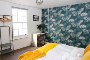 een slaapkamer met een bed met groen en wit behang bij Heart of Brighton City Centre by 9S Living in Brighton & Hove